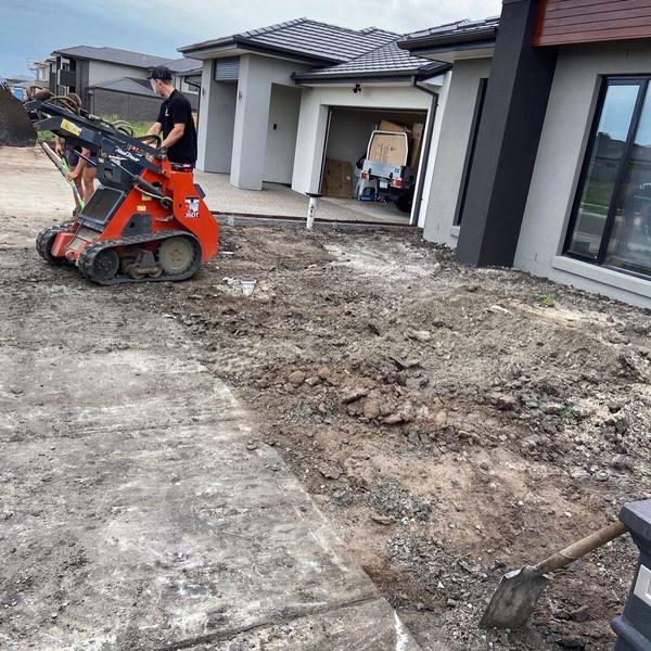 A man driving an excavator to perform a landscaping task.