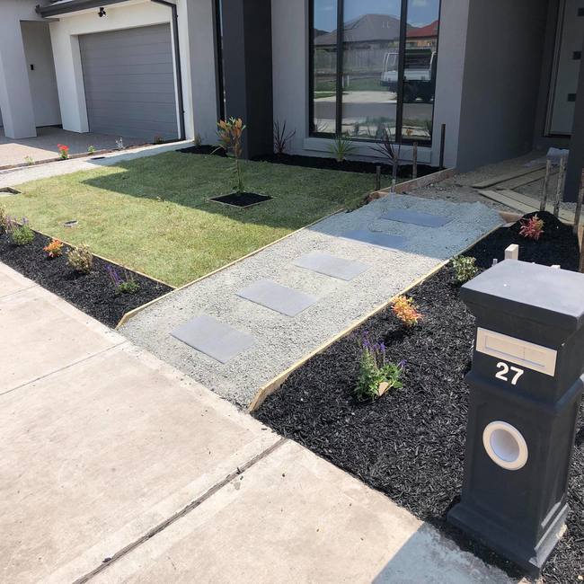 Natural front lawn turf, with a grey pavement and black letterbox.