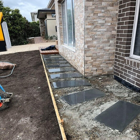 Bluestone pavers in an unfinished front yard.