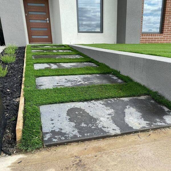 Bluestone pavers on artificial turf in a south eastern Melbourne front yard.